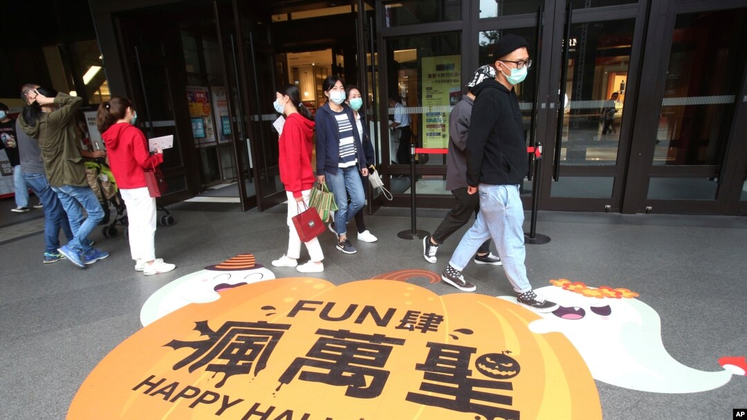 People wear face masks to protect against the spread of the coronavirus as they walk through a shopping district in Taipei, Taiwan, Oct. 29, 2020. 