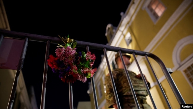 Un militar se encuentra cerca de flores en una cerca cerca de la escena donde un vehículo atropelló a una multitud durante las celebraciones de Año Nuevo, en Nueva Orleans, Luisiana, EEUU, el 1 de enero de 2025.