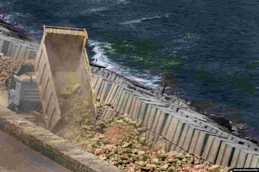 Government workers in Alexandria, Egypt, build up sea-front stone barriers to try to protect the city from rising sea levels. (Hamada Elrasam/VOA) 