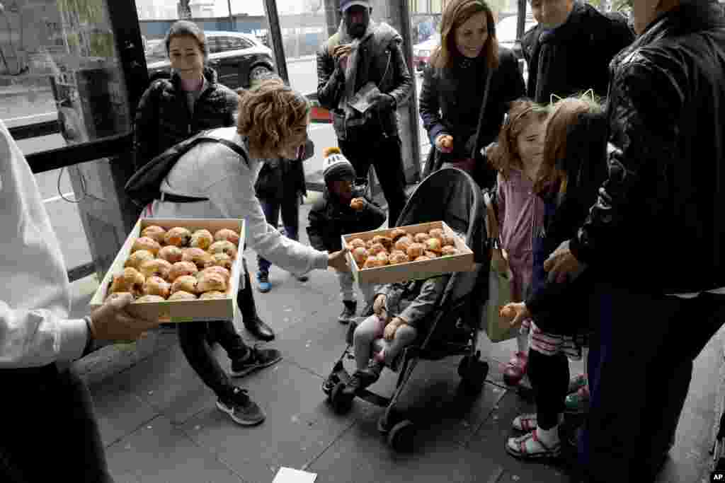 Pastries are offered to a French expat family arriving to vote in the French election at the Lycee Francais Charles de Gaulle school in the South Kensington district of London, May 7, 2017.