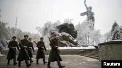 Para anggota Pasukan Kehormatan Rusia berjalan di sekitar patung "Motherland Calls" di Volgograd, Rusia (31/12).