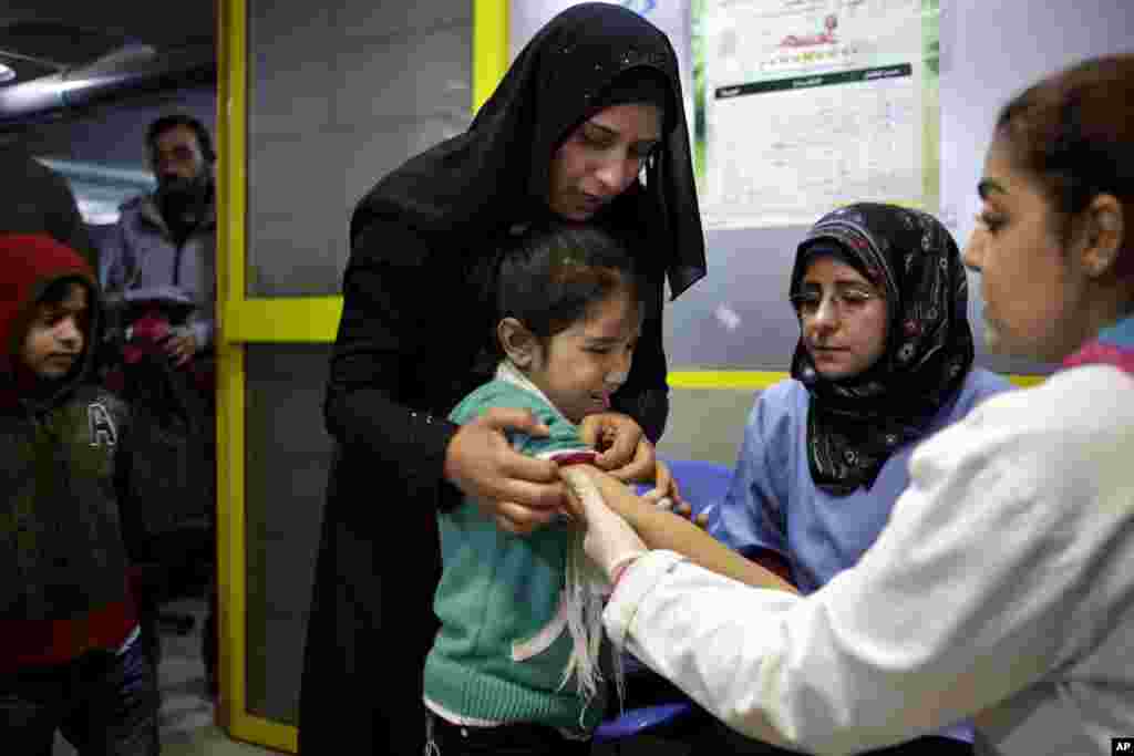 A Syrian girl cries after receiving the measles vaccine from UNICEF nurses at the U.N. refugee agency&#39;s registration center in Zahleh, Lebanon, Dec. 18, 2013.