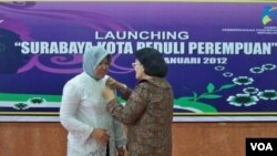 Staf Ahli Menteri Pemberdayaan Perempuan dan Perlindungan Anak, Emmy Rachmawati memasangkan PIN "Surabaya Kota Peduli Perempuan" kepada Walikota Surabaya Tri Rismaharini (19/1).