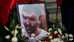 Flowers are placed around the portrait of Astrit Dehari during a funeral ceremony in Pristina, Kosovo, Nov. 8, 2016.