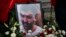 Flowers are placed around the portrait of Astrit Dehari during a funeral ceremony in Pristina, Kosovo, Nov. 8, 2016.