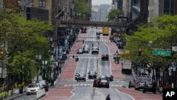 Pedestrians cross a nearly empty 42nd Street, May 8, 2020, in New York. 