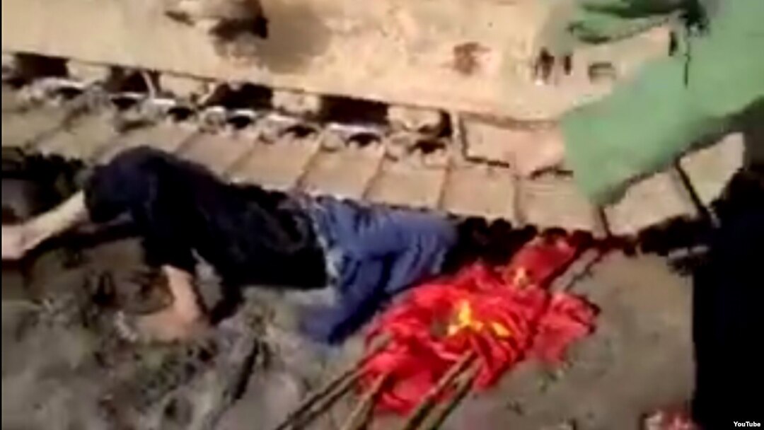 Nạn nhân nằm dưới bánh của máy xúc trong đoạn video clip gây xôn xao dư luận.