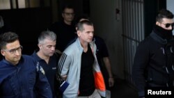 Alexander Vinnik, a Russian suspected of running a money laundering operation using bitcoin, is escorted by police officers while leaving a court in Thessaloniki, Greece, October 11, 2017.