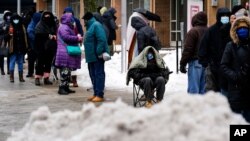 People wait in line for the opening of a 24-hour, walk-up COVID-19 vaccination clinic hosted by the Black Doctors COVID-19 Consortium at Temple University's Liacouras Center in Philadelphia, Friday, Feb. 19, 2021. Efforts to vaccinate Americans…