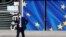 A man wearing a protective mask walks past the EU Commission headquarters amid the coronavirus outbreak, in Brussels, Belgium, Sept. 18, 2020. 