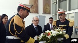 Le président tunisien Beji Caid Essebsi (au c.), lors de la remise d'une gerbe de fleurs à l'entrée du musée du Bardo à Tunis (AFP)