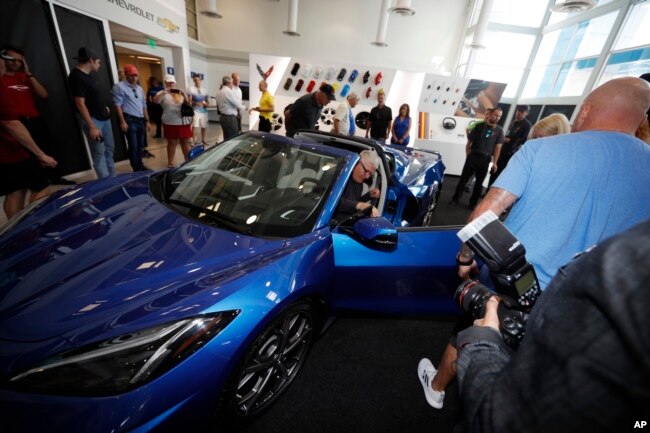 Buyers check out a 2020 Chevrolet Corvette during an unveiling of the mid-engine sports car for Corvette enthusiasts at a Chevrolet dealership Tuesday, Sept. 17, 2019, in Lone Tree, Colo. (AP Photo/David Zalubowski)