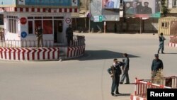 FILE - Afghan policemen keep watch at the downtown of Kunduz city, Afghanistan, Oct. 3, 2016.