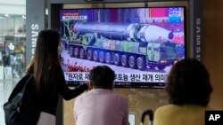 Orang-orang menonton layar TV yang menampilkan file gambar rudal Korea Utara dalam parade militer selama program berita di Stasiun Kereta Api Seoul di Seoul, Korea Selatan, Senin, 30 Agustus 2021. (AP Photo/Ahn Young-joon)