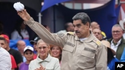 El presidente venezolano Nicolás Maduro lanza un pañuelo a simpatizantes durante una concentración oficialista en Caracas por el aniversario 165 de la Batalla de Santa Inés, el 10 de diciembre de 2024.