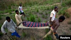 Des éléments de la Croix rouge transportent un mort sur une civière à Dungu, RDC, 17 février 2009.