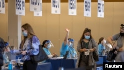 People are processed at the entrance to an empty department store being used as a vaccination center during the outbreak of the coronavirus disease (COVID-19) in Chula Vista, California, Jan. 21, 2021. 