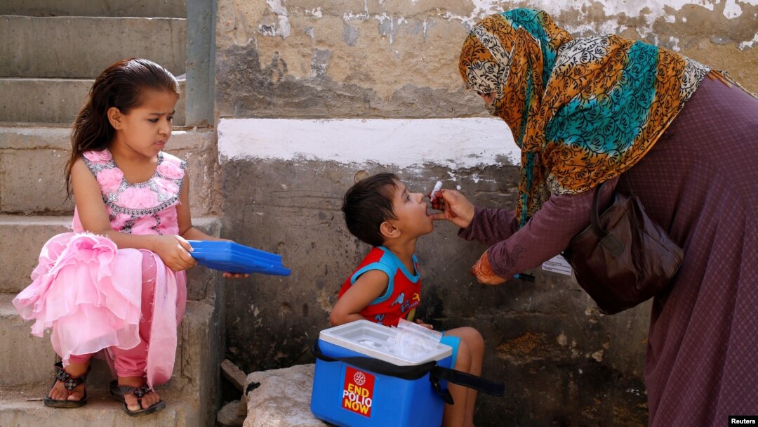 Seorang petugas medis memberikan vaksinasi polio kepada anak-anak dari rumah ke rumah di Pakistan (foto: ilustrasi). 