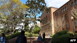 Estudiantes universitarios caminan por el recinto de la Universidad de California en Los Angeles (UCLA).