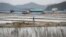 FILE - A man walks through a salt farm on Sinui Island, South Korea, April 3, 2014. A court ruled Sept. 8, 2017, that the South Korean government must pay 37 million won ($33,000) to a man who'd been held as a slave there. Three others also must be paid, a court ruled Friday.