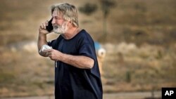 Alec Baldwin nói chuyện qua điện thoại trong bãi đậu xe bên ngoài Sở Cảnh sát Quận Santa Fe ở Santa Fe, bang New Mexico, sau khi ông được thẩm vấn về vụ nổ súng trên phim trường của phim "Rust", ngày 21 tháng 10, 2021.
