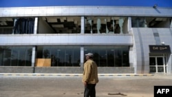 A man stands in front of a damaged building at Sanaa international airport on Dec. 27, 2024, following Israeli strikes at the site the previous day. 