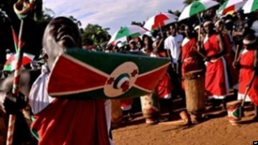 A traditional Burundian drummer dances with a shield and staff as he welcomoes a ruling party leader during a political rally at a sports field in Bujumbura, 11 May 2010