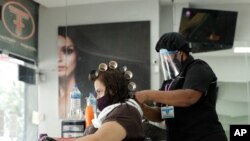 A hairstylist services a client at the Factory Fashion Beauty Salon in Panama City, Aug. 17, 2020. 
