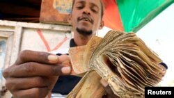 A dealer counts bundles of Somali shilling at an open air currency exchange in Mogadishu, Somalia, Feb. 5, 2020. The World Bank has normalized relations with Somalia and more than 100 IMF members have pledged to provide $334 million in debt relief.