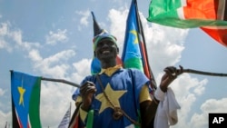 A man waves South Sudanese national flags during peace celebrations in the capital Juba, South Sudan, Oct. 31, 2018. 