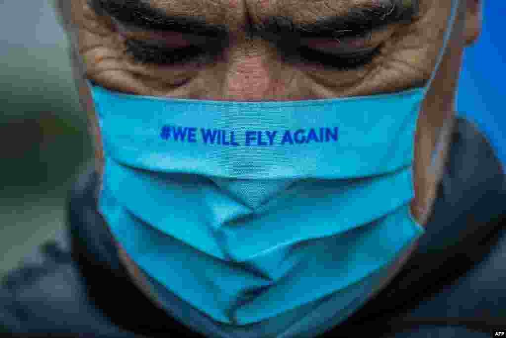 A TAP Air Portugal employee wearing a face mask reading "We will fly again" takes part in a protest against job cuts at TAP airline headquarters in Lisbon, Portugal.