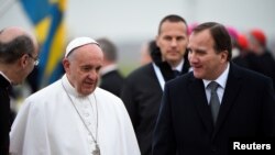 Le pape François et le Premier ministre suédois Stefan Lofven lors d'une cérémonie d'accueil à l'aéroport, en Suède, le 31 octobre 2016.