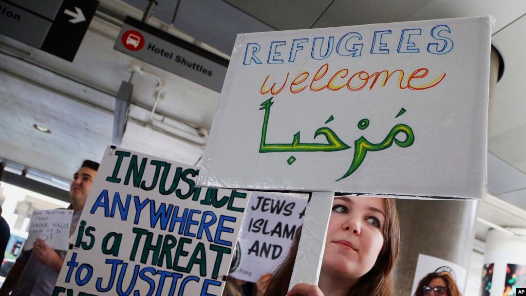 A woman holds a sign saying "welcome" in English and Arabic as demonstrators opposed to President Donald Trump's executive orders barring entry to the U.S. by residents of certain Muslim-majority countries protest at the Tom Bradley International Terminal