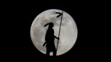 The moon rises in its full stage behind "The Guardian", a bronze, 17 foot statue representation of an American Indian man by Enoch Kelly Haney sitting atop the Oklahoma State Capitol building, Jan. 13, 2025, in Oklahoma City.