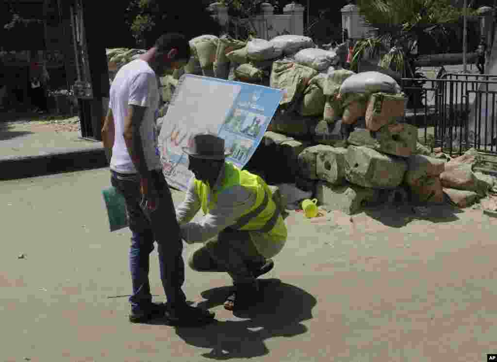 Một tình nguyện viên khám xét một ủng hộ viên của Tổng thống Ai Cập bị lật đổ Mohamed Morsi khi ông này tiến vào Quảng trường Nahda, Cairo, 12 tháng 8, 2013.