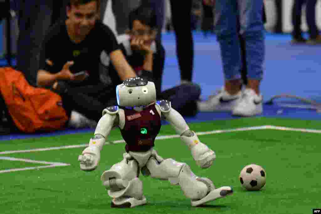 Visitors watch a competition of robot soccer players at the 7th edition of the Maker Faire 2019, a huge European event on innovation, in Rome.