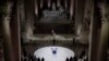 French President Emmanuel Macron stands by the coffin of World War I fighter Maurice Genevoix inside the Pantheon monument in Paris.