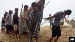 Vietnamese villagers move a fishing boat on shore in northern Thanh Hoa province, Vietnam, Sept. 14, 2017. Vietnam braced Thursday for Typhoon Doksuri, which was expected to be the most powerful tropical cyclone to hit the Southeast Asian country in several years.