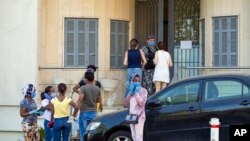 Ethiopian workers wait outside the Ethiopian Consulate in Hazmieh, Beirut, Lebanon, where some 250,000 registered migrant laborers are growing more desperate as a crippling economic and financial crisis sets in, coupled with coronavirus restrictions.