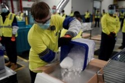 FILE - Boxes containing the Pfizer-BioNTech COVID-19 vaccine are prepared to be shipped at the Pfizer Global Supply Kalamazoo manufacturing plant in Portage, Michigan, Dec. 13, 2020.
