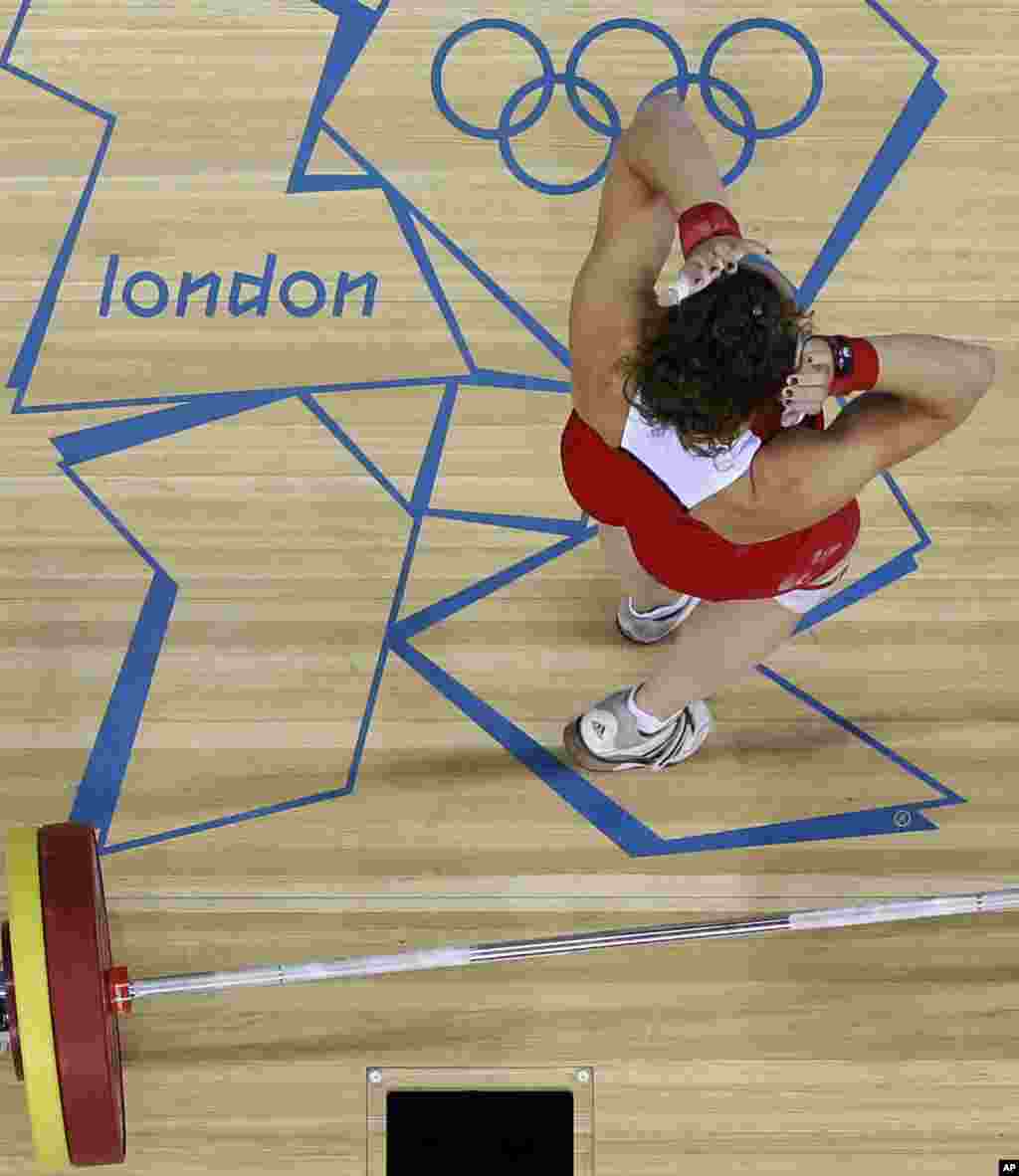 Annie Moniqui de Canadá reacciona durante la competencia de levantamiento de pesas, mujeres, categoría de 58-kg.