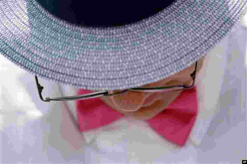 A spectator reads a racing program before the 138th running of the Kentucky Oaks horse race at Churchill Downs Friday, May 4, 2012, in Louisville, Ky. (AP Photo/Matt Slocum)