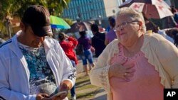 FILE - Maria Elena Arias Gonzalez reacts with elation to receiving her U.S. visa, outside the U.S. Interests Section in Havana, Cuba, Jan. 21, 2015. 