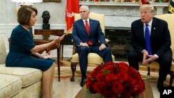 Umsekeli kamongameli, uMnu.Mike Pence,ophahliweyo, ukhangela usolomlomo wedale le uNkosikazi Nancy Pelosi ephedula uMonameli Donald Trump.