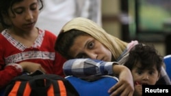 Asylum seekers hoping to reach Australia, wait in a police station in Surabaya , East Java province July 29, 2012. 