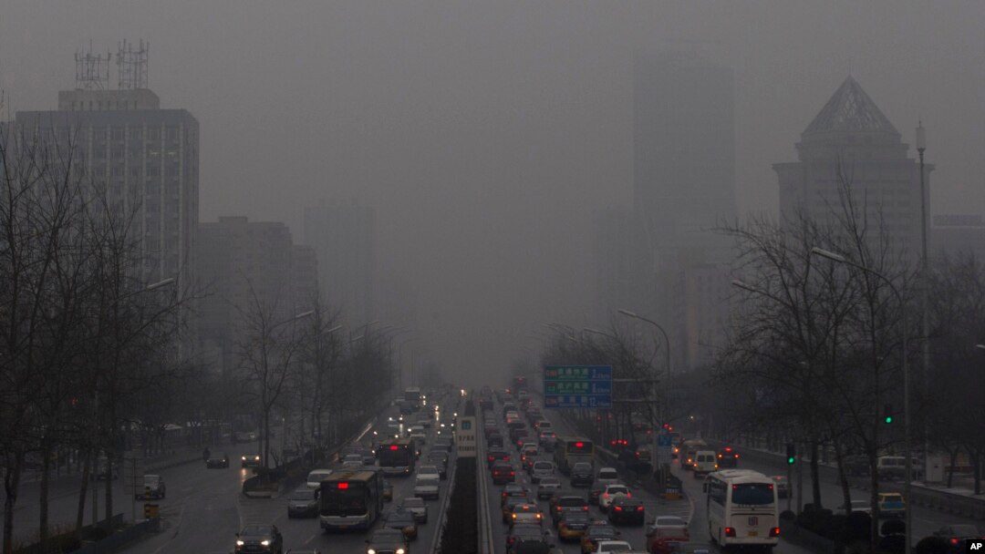 Antrian panjang kendaraan terlihat di jalanan Beijing diantara gedung-gedung pencakar langit yang tertutup asap polusi (Foto: dok). Sebagian ilmuwan mengatakan kegiatan manusia dan polusi dari mobil dan pabrik juga ikut berperan dalam memanasnya suhu Bumi.