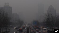 Antrian panjang kendaraan terlihat di jalanan Beijing diantara gedung-gedung pencakar langit yang tertutup asap polusi (Foto: dok). Sebagian ilmuwan mengatakan kegiatan manusia dan polusi dari mobil dan pabrik juga ikut berperan dalam memanasnya suhu Bumi.