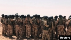 Les forces spéciales nigériennes font le point avec leurs formateurs canadiens après des exercices de silex à Ouallam, au Niger, le 18 avril 2018.