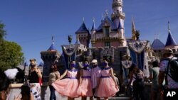 지난 30일 캘리포니아주 애너하임에 있는 디즈니랜드에서 한 가족이 사진을 찍고 있다. 신종 코로나바이러스 여파로 문을 닫았던 디즈니랜드가 13개월 만에 다시 문을 열었다. 