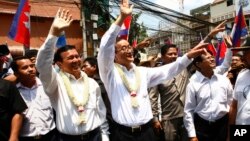 Cambodia's opposition leader Sam Rainsy, center, of the Cambodia National Rescue Party waves along with his party Vice President Kem Sokha, third from left, during a march in Phnom Penh, file photo. 